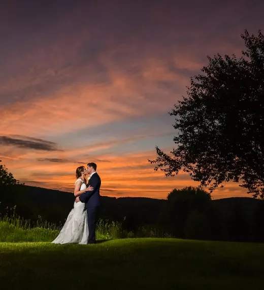 Bride and Groom standing together in the sunset surrounded by mountains