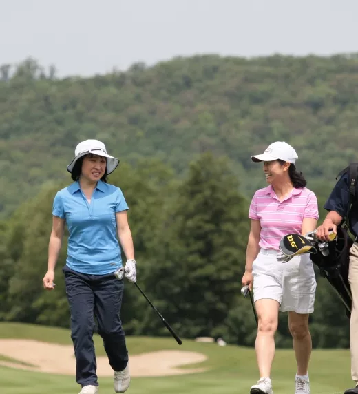 Two women and caddy walking to the next hole on a course at Crystal Springs Resort