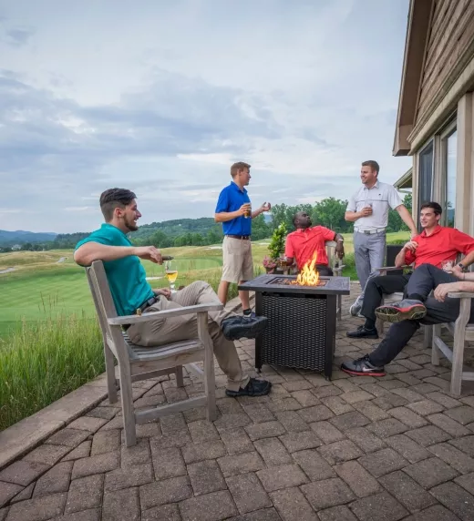 Guys sitting around a fire pit at a golf resort near NYC