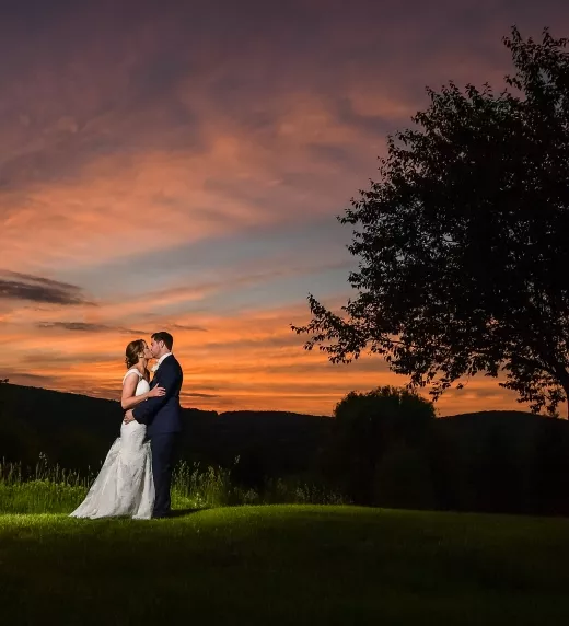 Bride and Groom standing together in the sunset surrounded by mountains