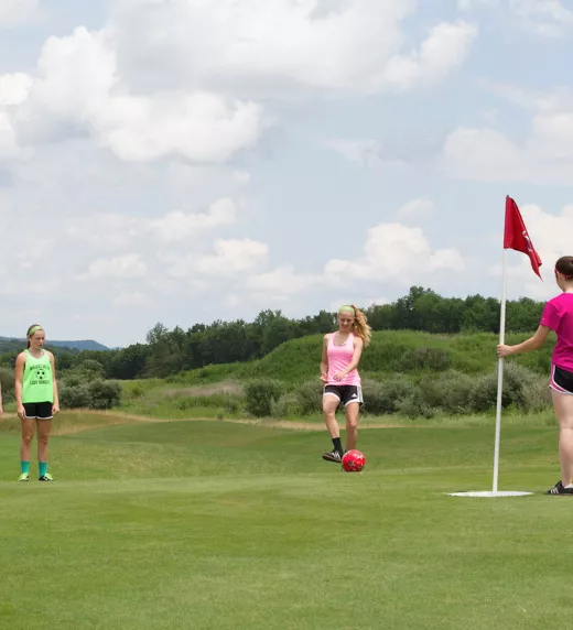 Four girls on a golf course at a resort near NYC playing foot golf