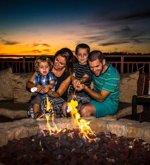 Family roasting marshmallows on the Fire and Water Terrace at Grand Cascades Lodge.