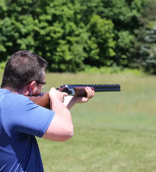 Man shooting gun at laser clay targets.