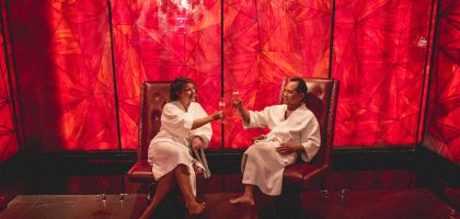 Couple sitting in Reflections Spa salt room cheersing champagne