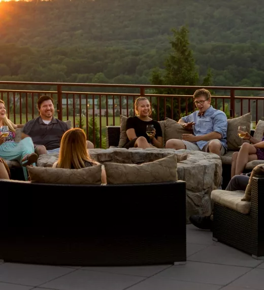 A corporate group enjoying drinks on the Fire + Water Terrace at sunset