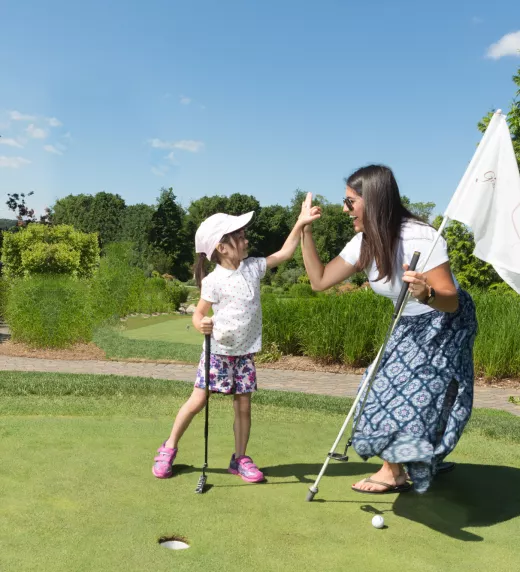 Mother and daughter at the natural grass putting course at Grand Cascades Lodge