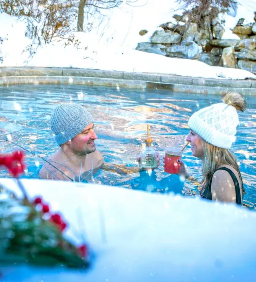 A couple enjoying drinks in an outdoor pool at Crystal Springs Resort