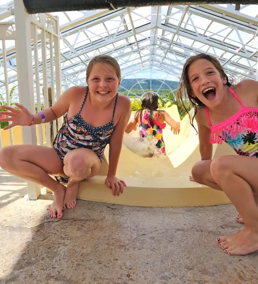 Two girls at top of Biosphere pool complex indoor slide.