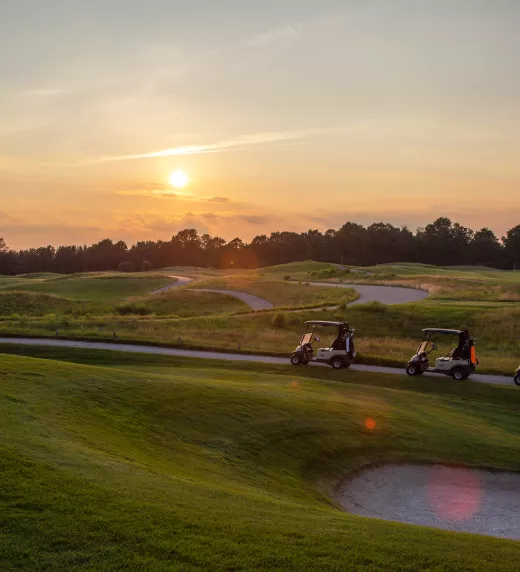 Golf carts on the Ballyowen golf course at sunset