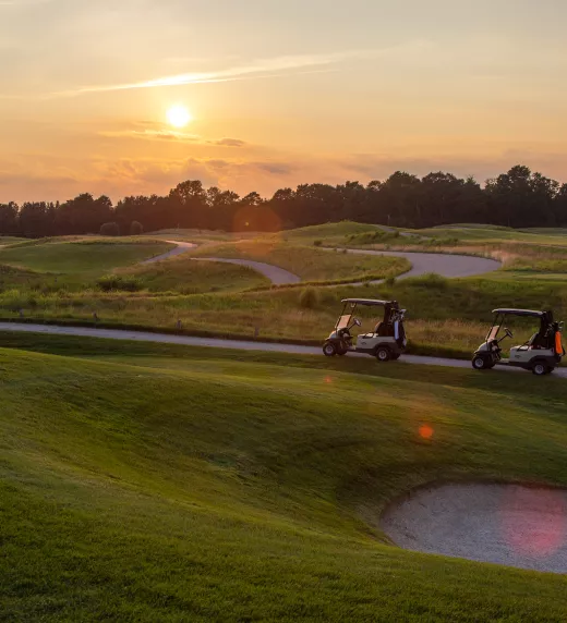 Golf carts on the Ballyowen golf course at sunset