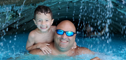 Father and Son under waterfall at minerals pool