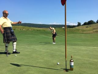 Two people wearing kilts playing a round of golf at Ballyowen Golf Club
