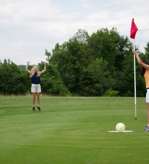 Two girls playing footgolf.