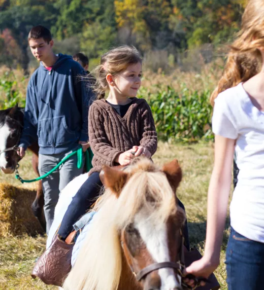 Girl riding a pony in Fall.