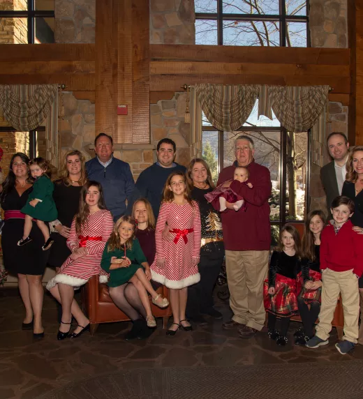 Family Christmas photo standing inside Grand Cascades Lodge