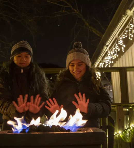 Two children warming up hands above fire at Frosty's Cantina