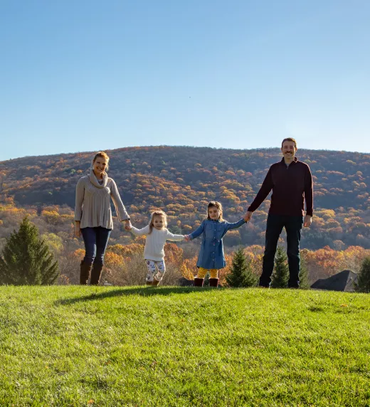 Family standing amongst the fall foliage at GCL.