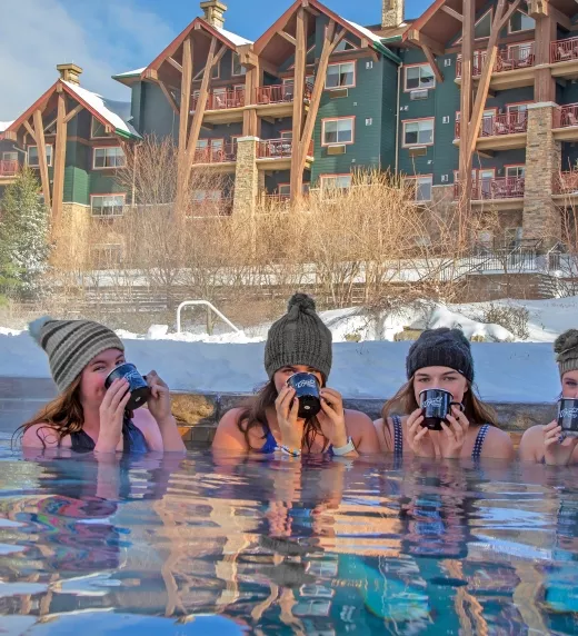 Girlfriends enjoying drinks in the snow pool at Grand Cascades Lodge