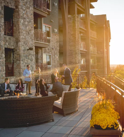 A corporate group enjoying an evening at the Fire + Water Terrace at Grand Cascades Lodge