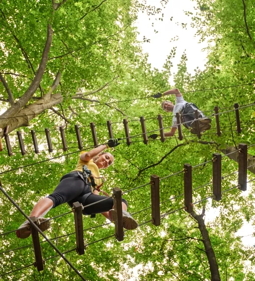 Two people on ropes course ladders.
