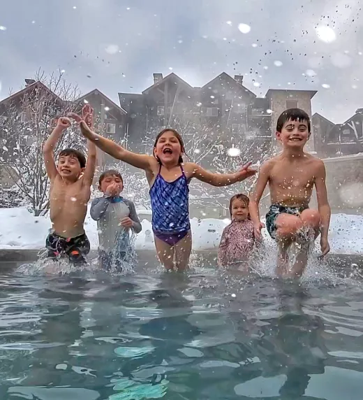 Kids jumping into snow pool at Grand Cascades Lodge 