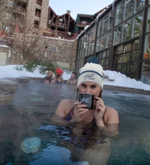 Woman enjoying hot chocolate in the snow pool