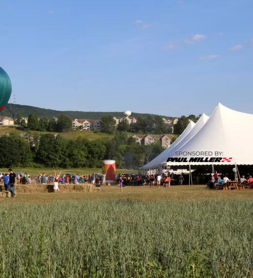 Large white tent with hot air balloon next to it.