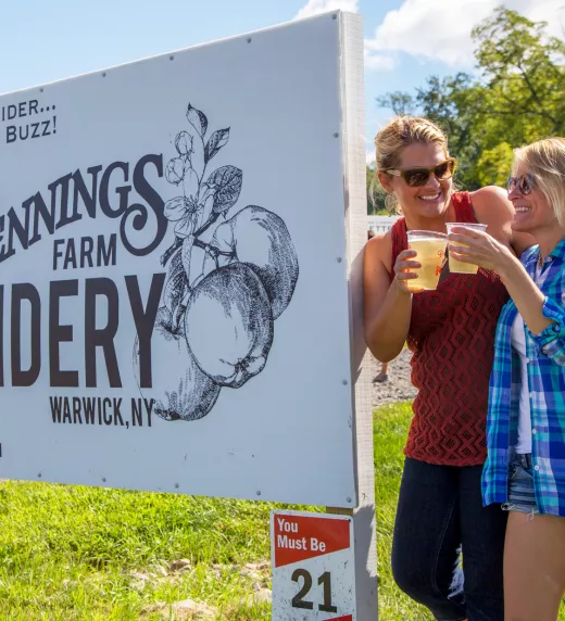 Girlfriends standing next to Pennings Cidery sign.
