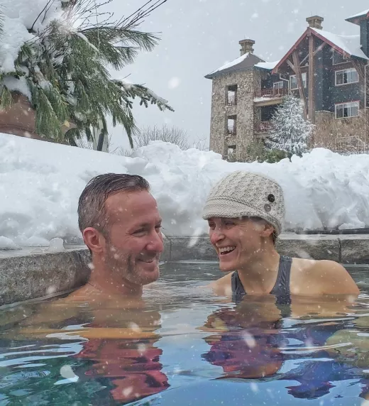 Couple in outdoor snow pool at Grand Cascades Lodge.
